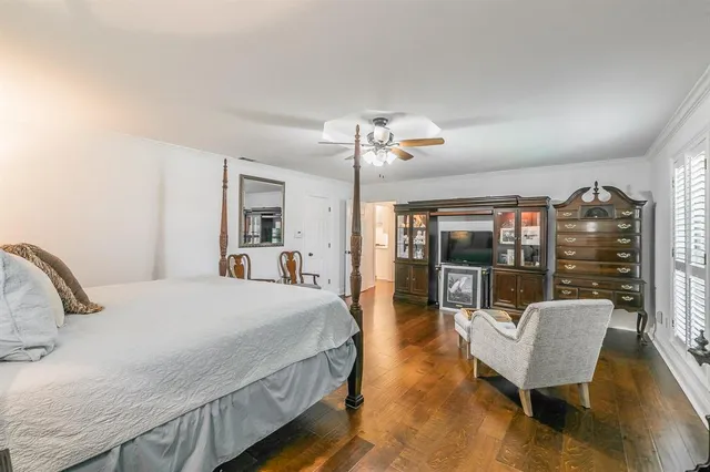 a bedroom with a bed wooden floor and lamp