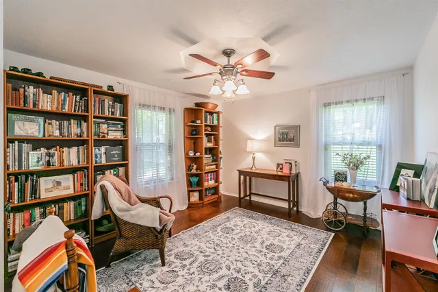 a living room with furniture a rug and a book shelf