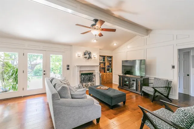 a living room with furniture a fireplace and a floor to ceiling window