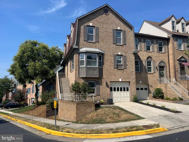 an empty room with wooden floor fireplace and windows