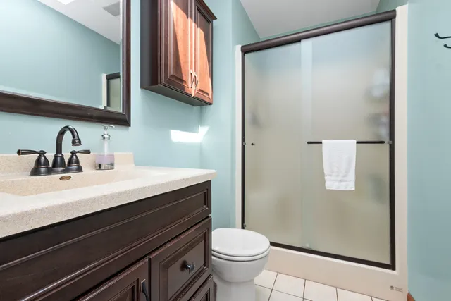 a bathroom with a sink a toilet a mirror and shower