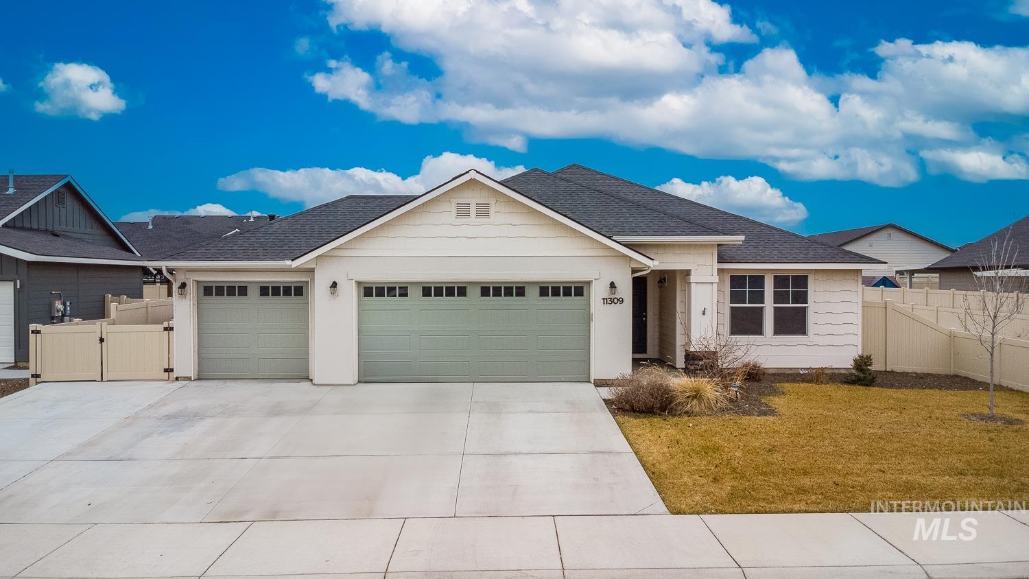 Ranch-style house featuring a garage, roof with shingles, concrete driveway, and a gate