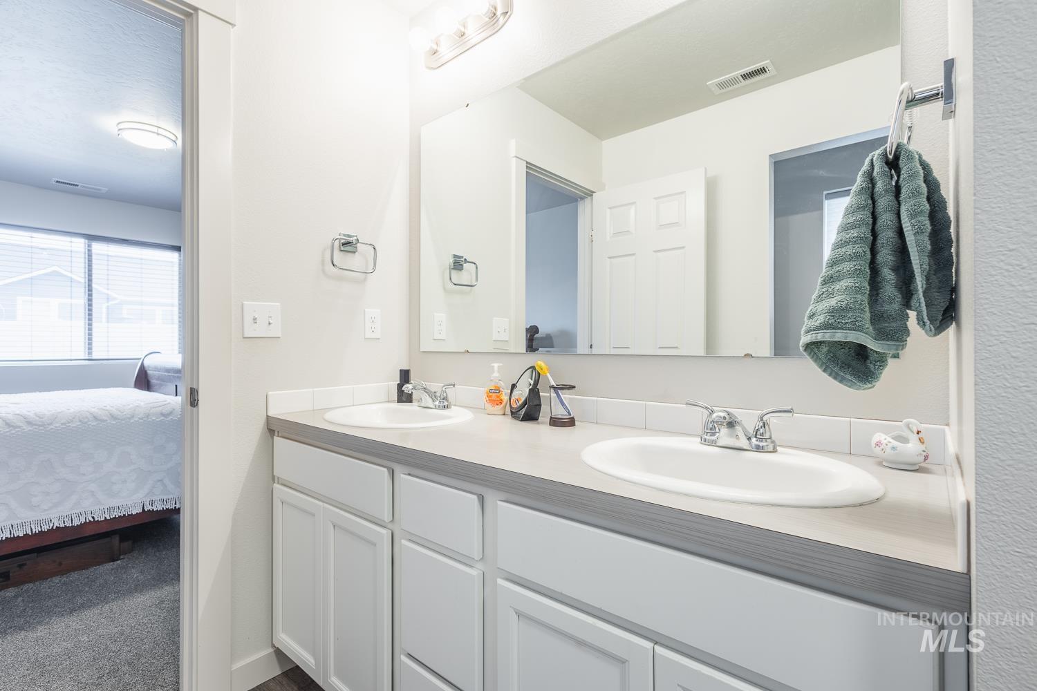 11309 West Viola Street Nampa, ID 83651 - Photo 24 of 37 Bathroom featuring double vanity, connected bathroom, and dark carpet
