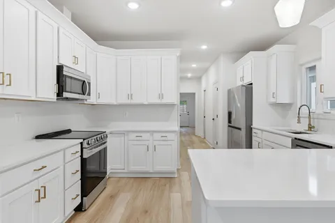 a kitchen with white cabinets and stainless steel appliances