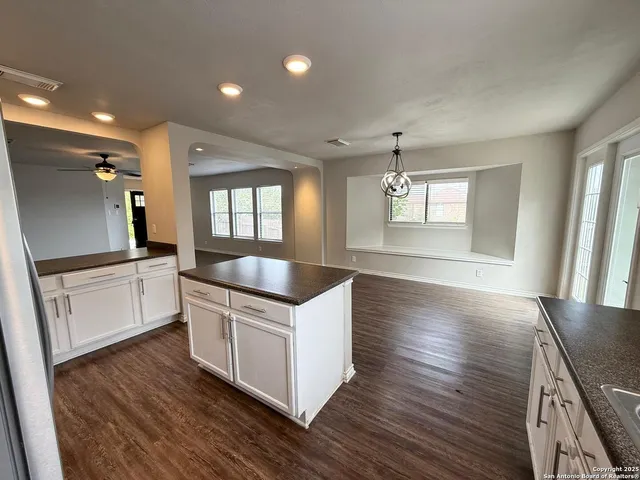 a kitchen with granite countertop a sink and a stove top oven
