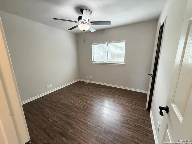 a view of a room with wooden floor and ceiling fan