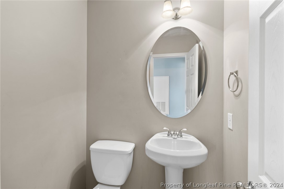 519 Cape Fear Road Raeford, NC 28376 - Photo 11 of 39 a bathroom with a toilet sink and mirror