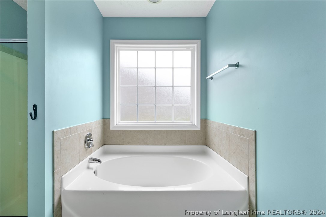 519 Cape Fear Road Raeford, NC 28376 - Photo 16 of 39 a white bath tub sitting in a bathroom next to a window