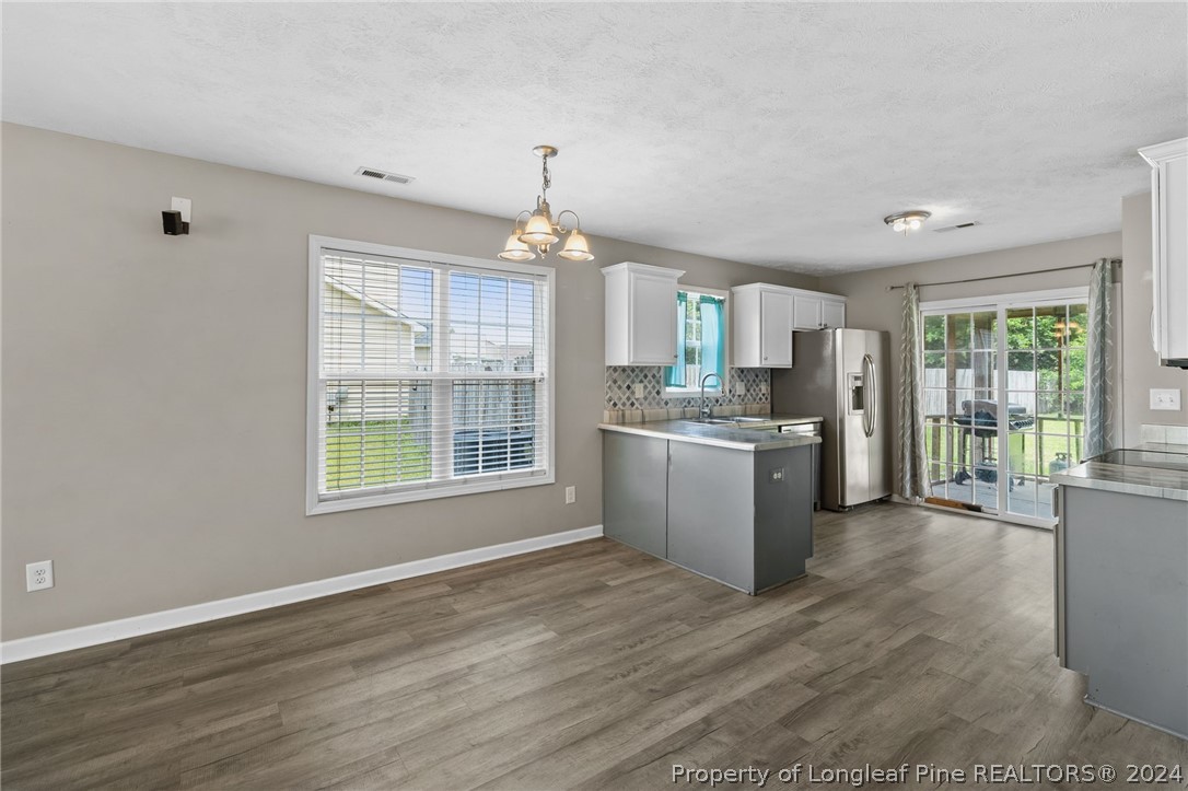 519 Cape Fear Road Raeford, NC 28376 - Photo 7 of 39 a kitchen with stainless steel appliances granite countertop a stove a sink dishwasher a refrigerator white cabinets and wooden floor next to a window