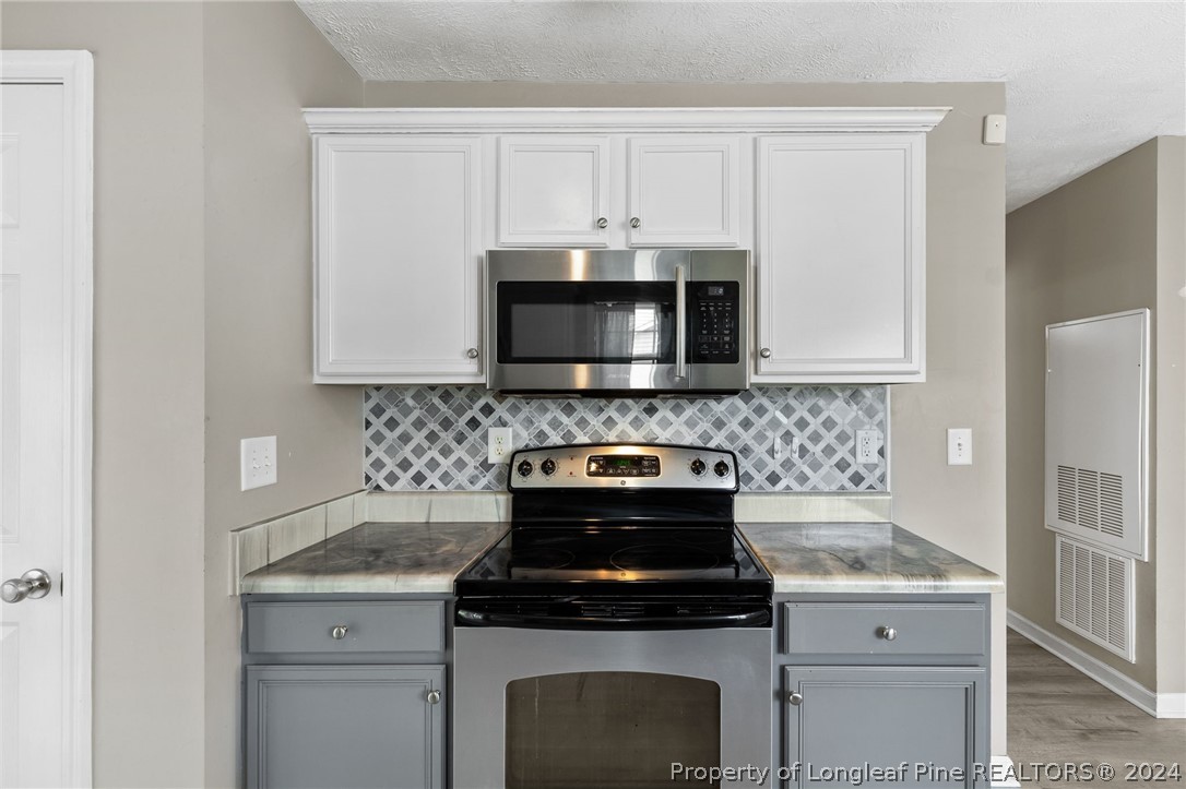 519 Cape Fear Road Raeford, NC 28376 - Photo 10 of 39 a kitchen with granite countertop white cabinets and black stove top oven with granite countertops
