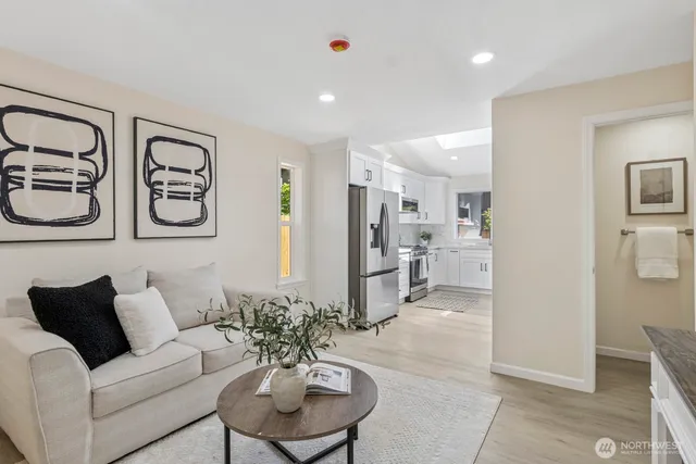 a living room with furniture white walls and kitchen view