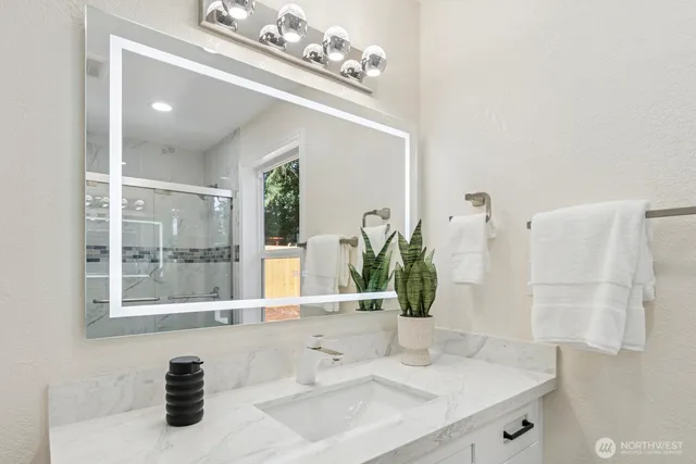 a kitchen with stainless steel appliances a refrigerator a sink a stove a microwave a dining table and chairs