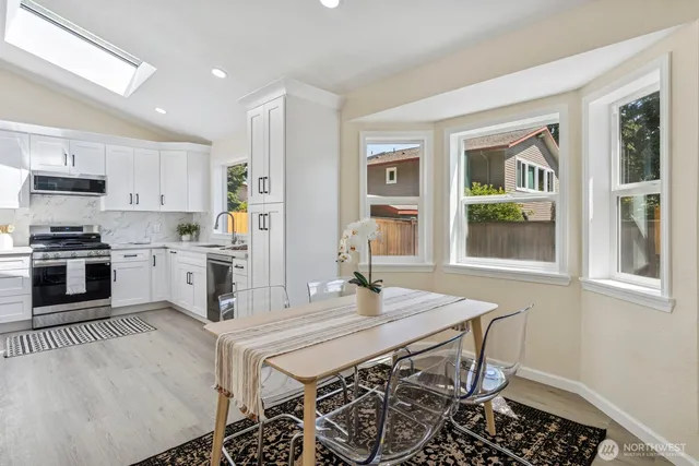 a kitchen with granite countertop a stove a sink and a refrigerator