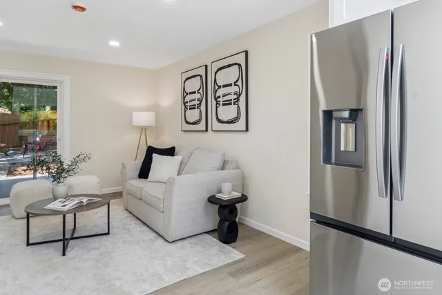 a living room with furniture and a refrigerator