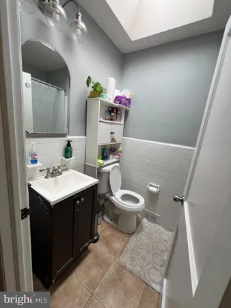 a bathroom with a sink vanity mirror and toilet