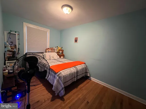 a bedroom with a bed and a lamp on dresser