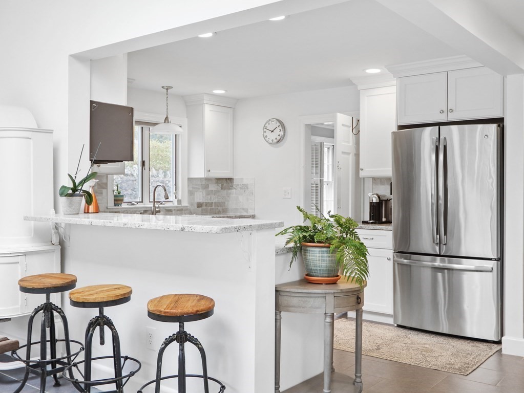 40 Whittier Road Newton, MA 02460 - Photo 5 of 20 a kitchen with stainless steel appliances granite countertop a dining table chairs refrigerator and sink