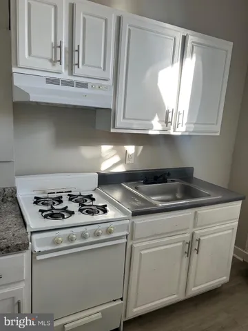 a white stove top oven sitting inside of a kitchen