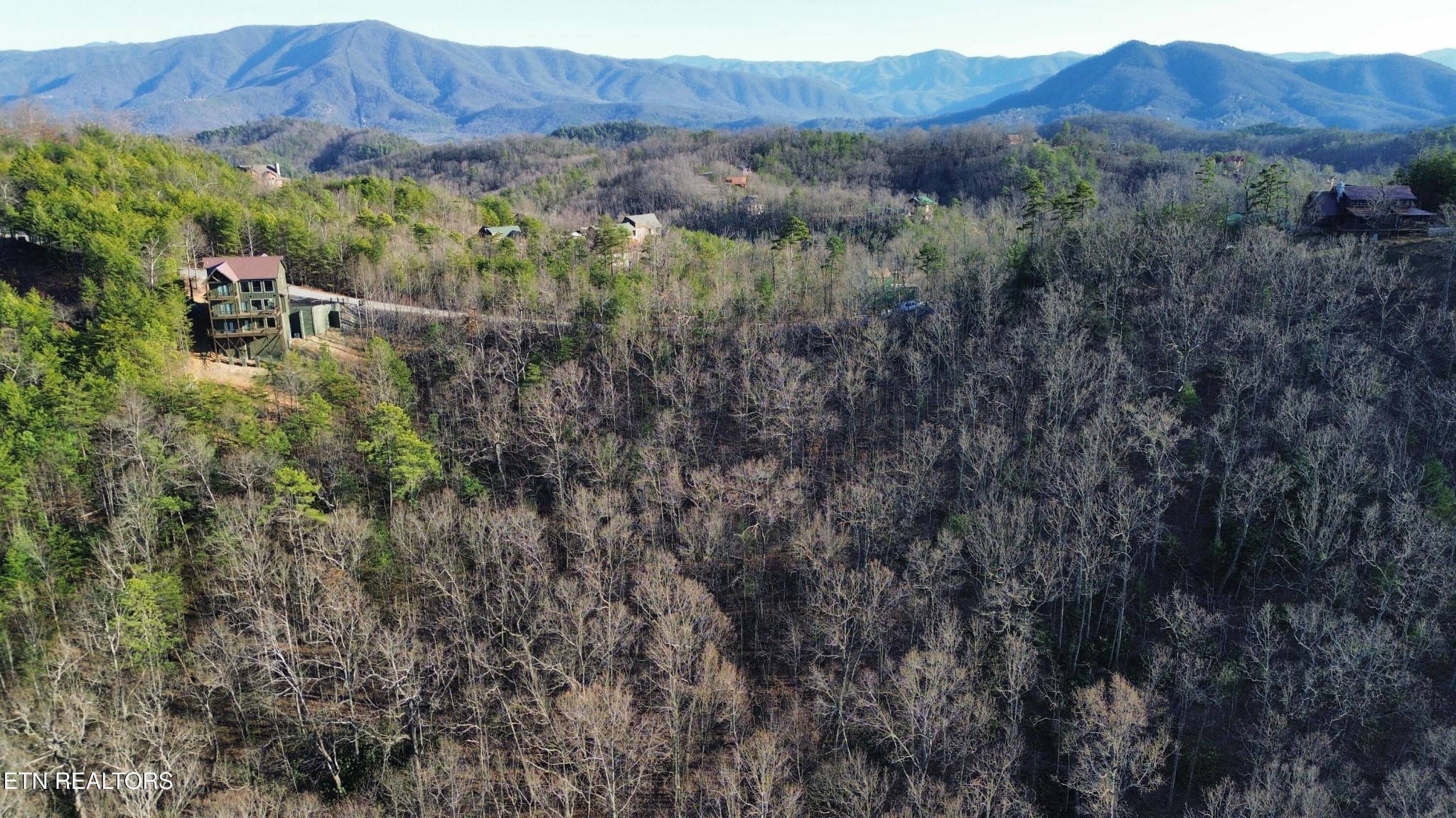 0 Stackstone Road Sevierville, TN 37862 - Photo 11 of 21 a view of a lush green forest with mountains and a wooden fence