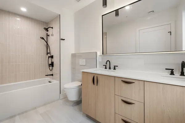 a bathroom with a sink a toilet and shower