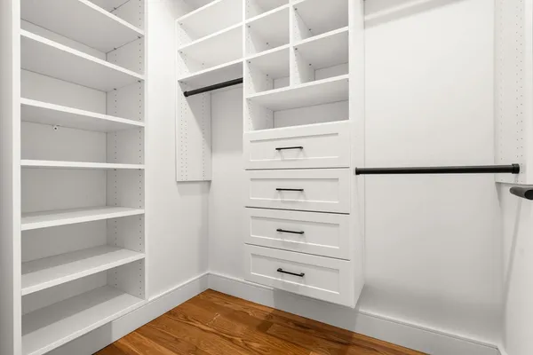 a view of walk in closet with empty racks