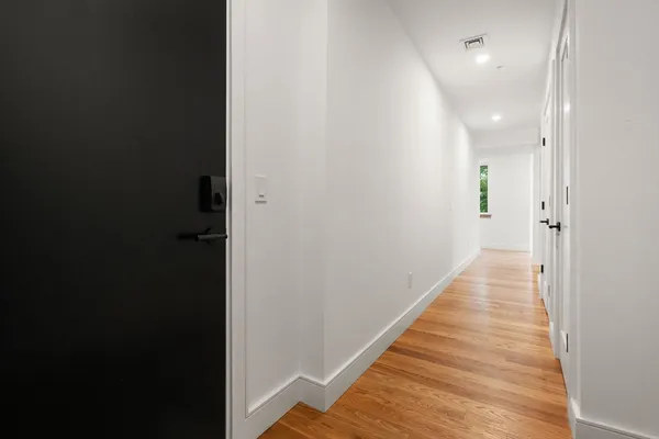 a view of a hallway with wooden floor