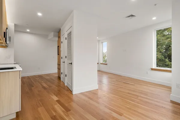 a view of a kitchen with wooden floor and a window