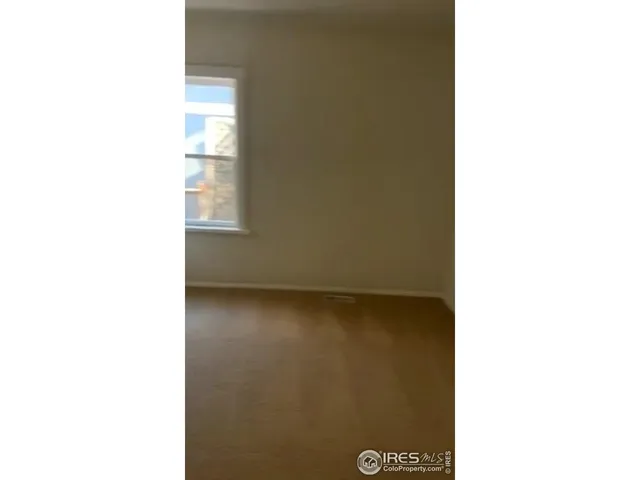 a view of a room with a white wall and a window