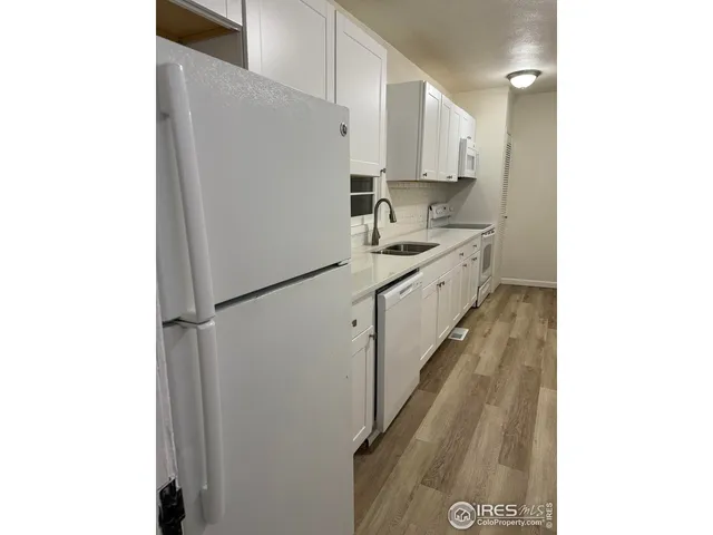 a kitchen with white cabinets and white appliances