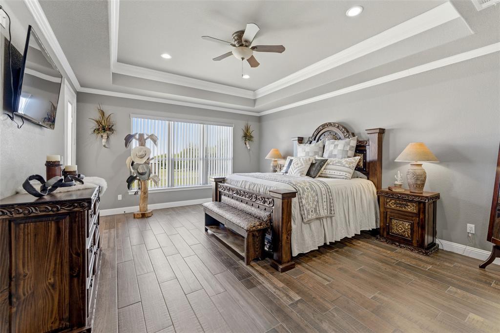 10106 Prather Road Springtown, TX 76082 - Photo 13 of 40 a bedroom with bed a flat tv screen and dresser
