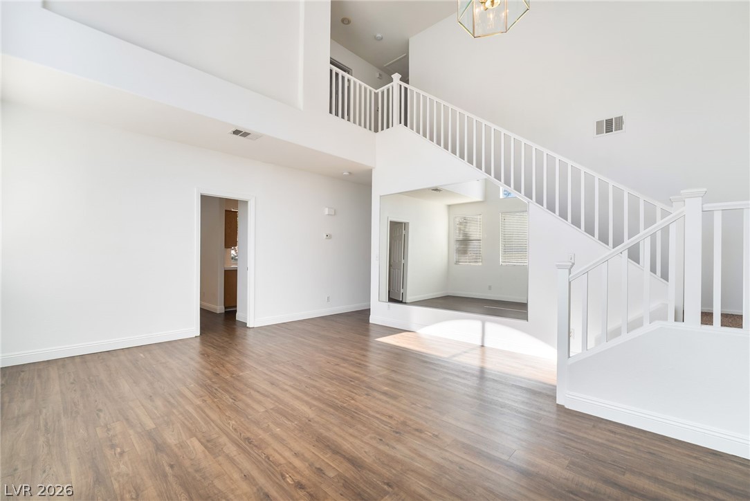 1988 Thunder Ridge Circle Henderson, NV 89012 - Photo 8 of 46 Unfurnished living room with wood finished floors and a high ceiling
