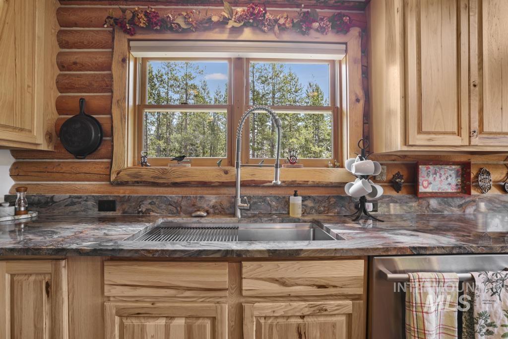 65 Goat Creek Way Stanley, ID 83278 - Photo 15 of 32 Kitchen featuring a stainless steel undermount sink with a gooseneck faucet, set within a patterned stone countertop
