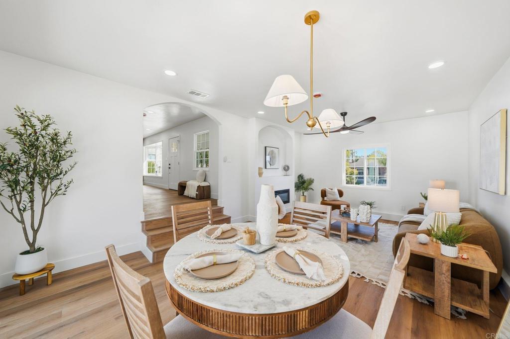 4920 Elsa Road San Diego, CA 92120 - Photo 19 of 46 a dining room with wooden floor a chandelier a wooden table and chairs