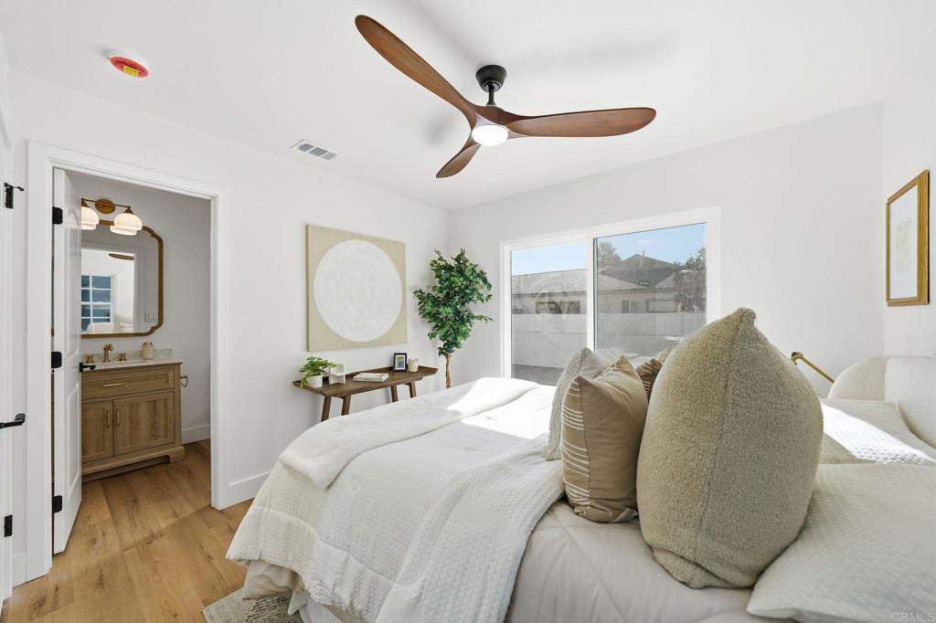 4920 Elsa Road San Diego, CA 92120 - Photo 24 of 46 a bedroom with a bed large window and wall painting