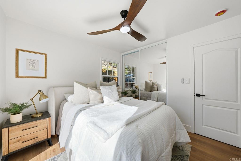 4920 Elsa Road San Diego, CA 92120 - Photo 25 of 46 a bedroom with a bed and a chandelier