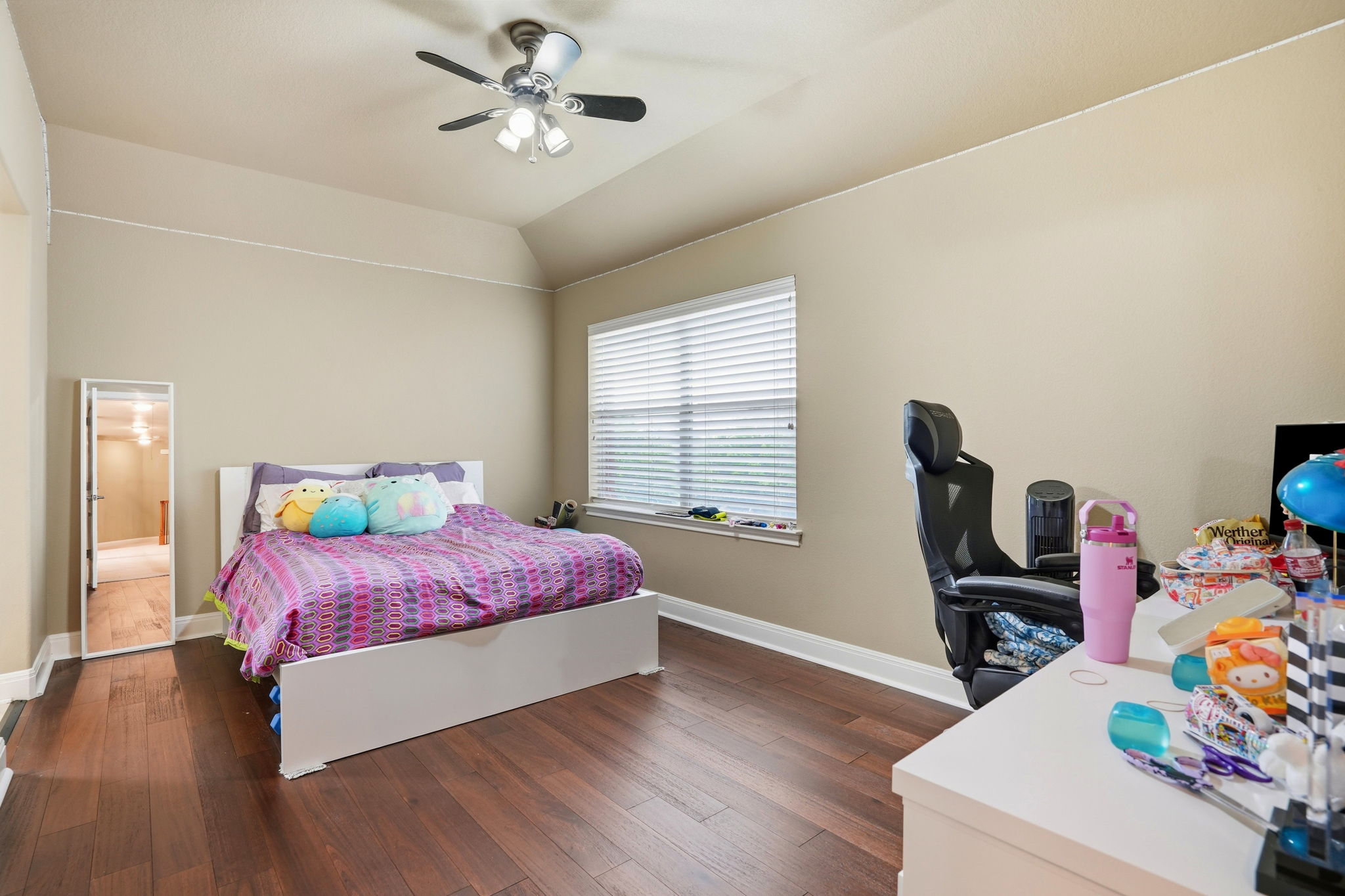 222 Vailco Lane Austin, TX 78738 - Photo 26 of 39 Spacious room featuring wood-finish flooring, a tray ceiling, and a ceiling fan with integrated lighting