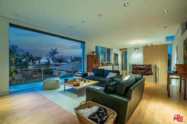 a living room with furniture and a floor to ceiling window