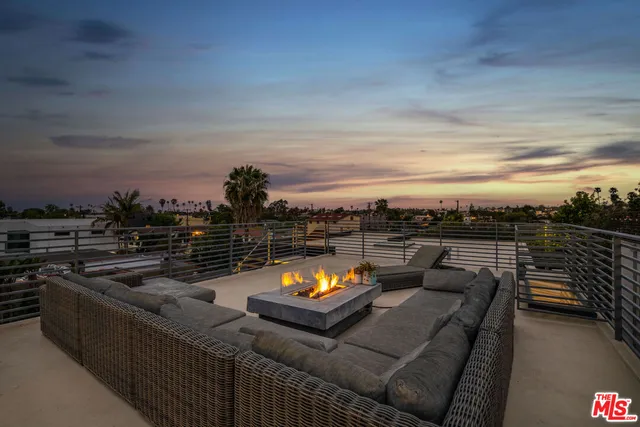 a view of a roof deck with couches and sky view