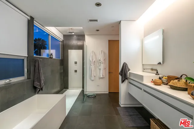 a bathroom with a tub sink and mirror
