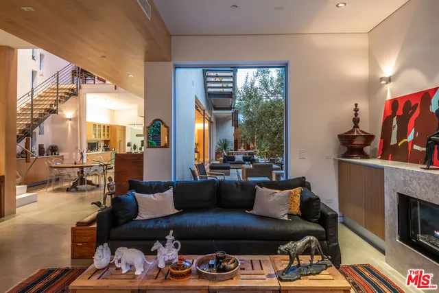 a living room with furniture a fireplace and a large window