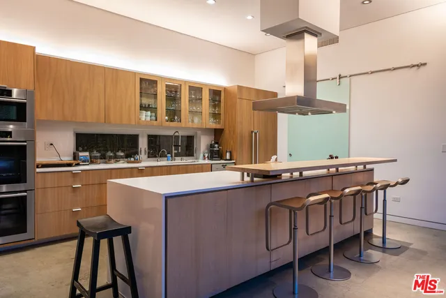 a kitchen with stainless steel appliances granite countertop a sink a stove and a refrigerator