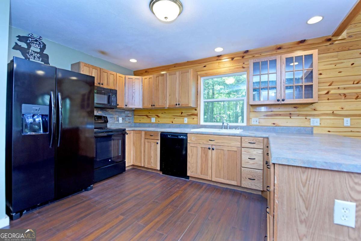 3373 Hardscrabble Road Mineral Bluff, GA 30559 - Photo 26 of 50 a kitchen with stainless steel appliances granite countertop a refrigerator a sink dishwasher a stove and a dining table with wooden floor