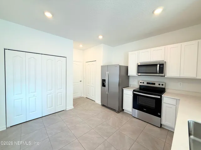 a kitchen with stainless steel appliances granite countertop a refrigerator and a stove top oven