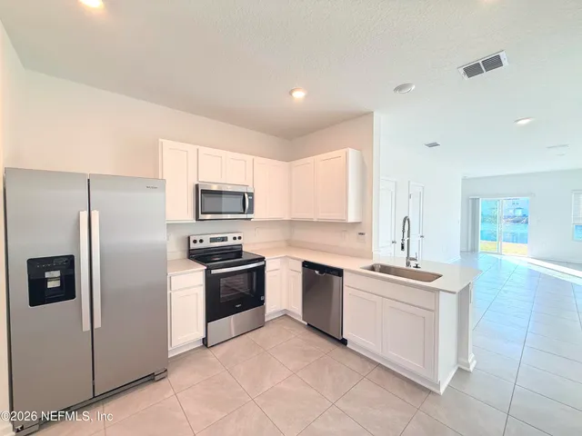 a kitchen with stainless steel appliances a stove sink and microwave