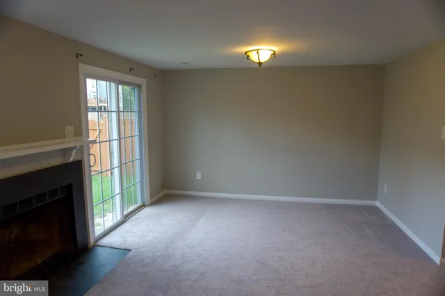 a view of empty room with window and fireplace