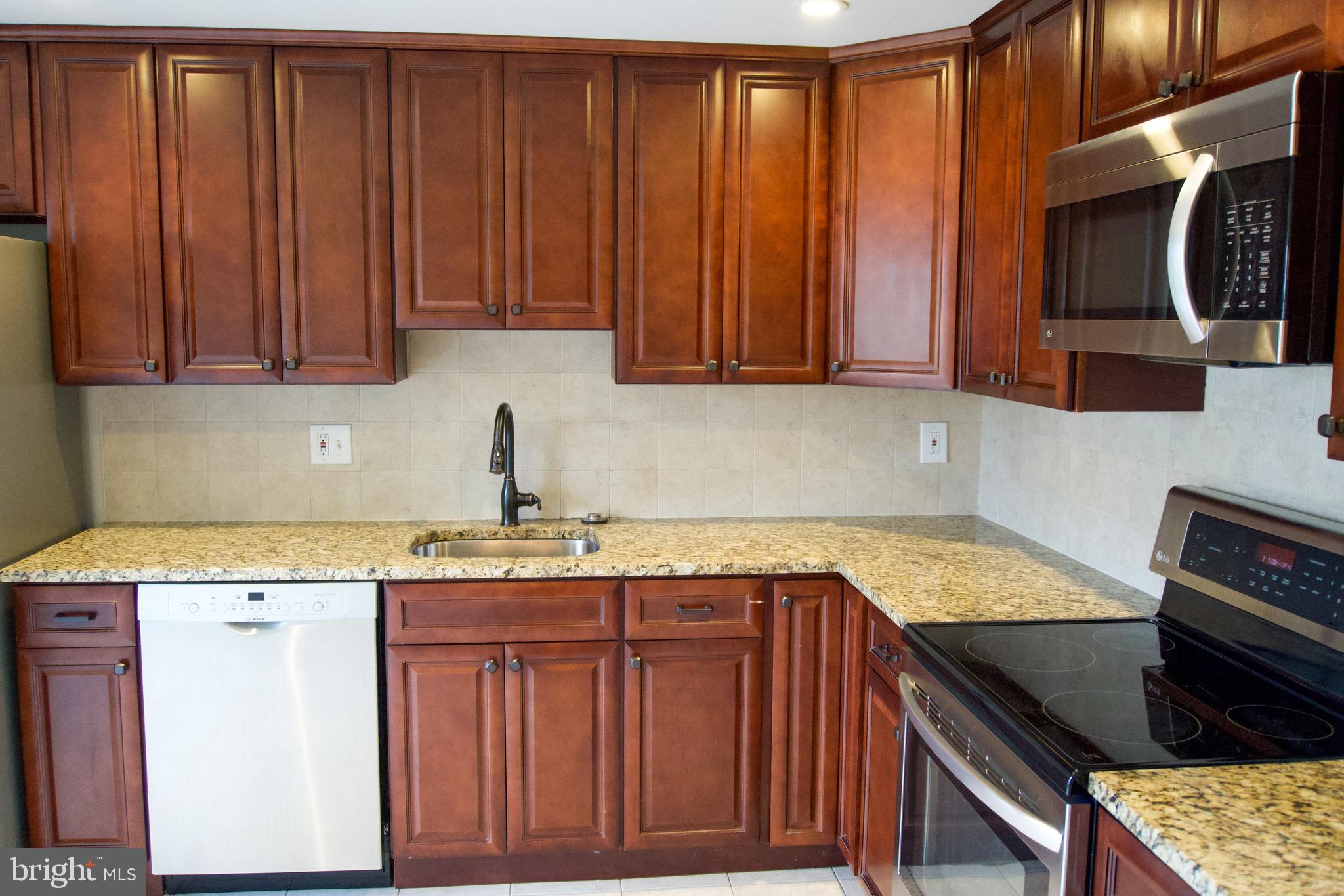 7341 Crestleigh Circle Alexandria, VA 22315 - Photo 6 of 21 a kitchen with a sink a stove cabinets and a window