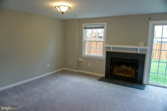 an empty room with a fireplace and window