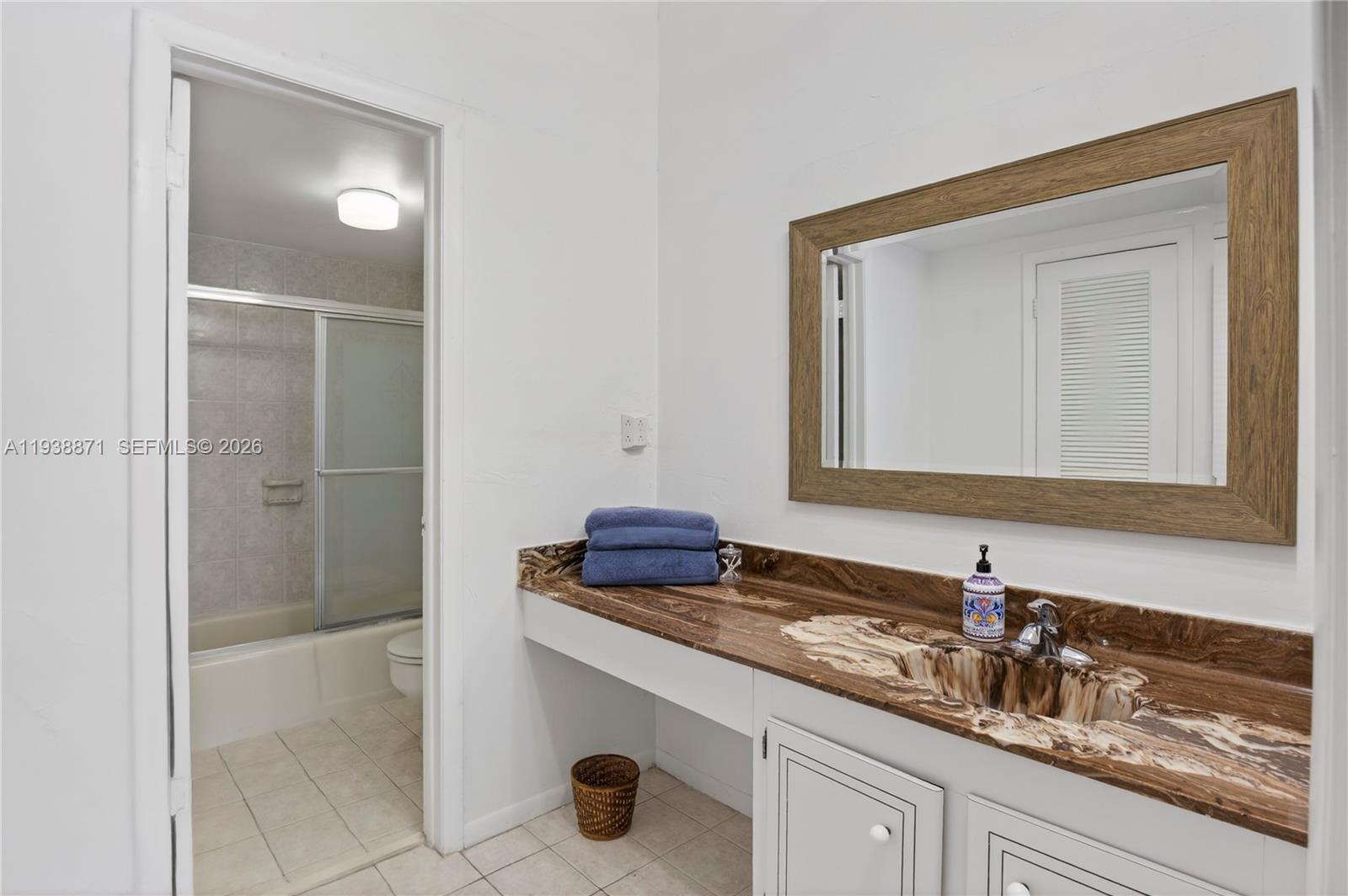 7673 Southwest 103rd Place Miami, FL 33173 - Photo 12 of 20 a bathroom with a granite countertop sink and a mirror