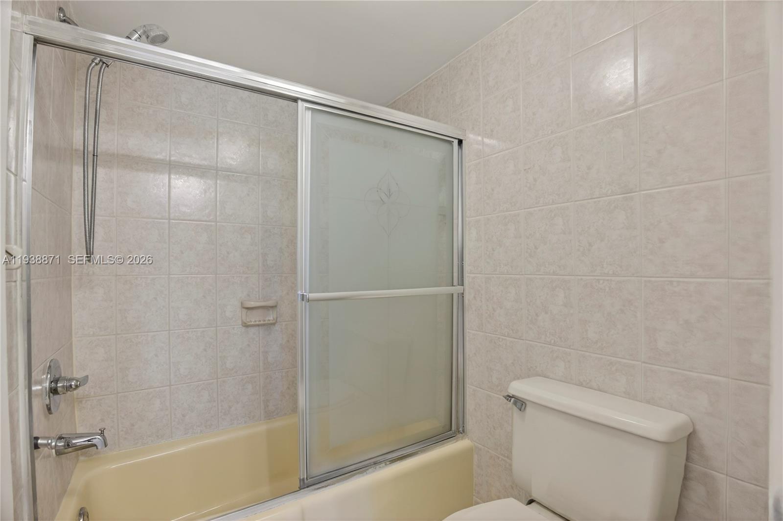 7673 Southwest 103rd Place Miami, FL 33173 - Photo 13 of 20 a bathroom with a shower a toilet and a sink