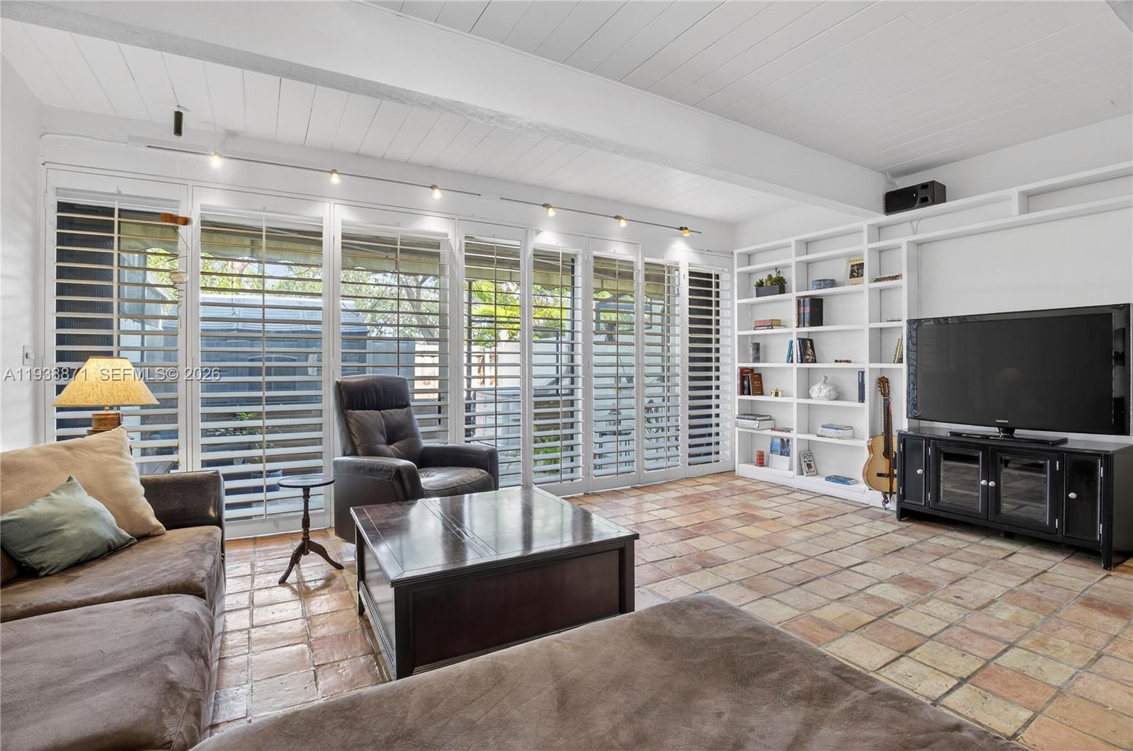 7673 Southwest 103rd Place Miami, FL 33173 - Photo 2 of 20 a living room with furniture and a flat screen tv